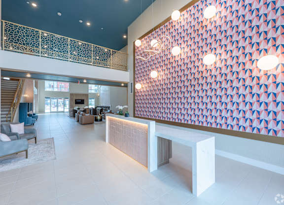 A large room with a staircase and a wall with lights.