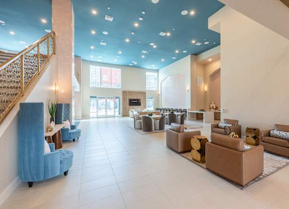A spacious living room with a staircase on the left and a large window on the right.