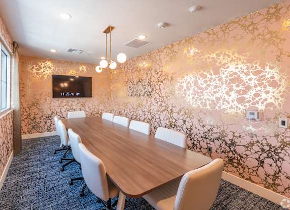 A conference room with a long table and chairs.
