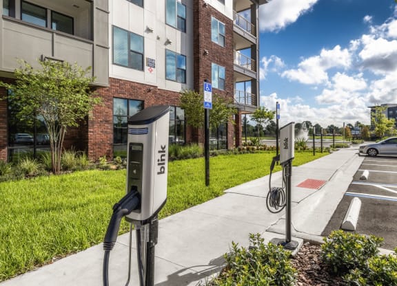 an electric car charging station in front of an apartment building at The Haven at Lake Britt Apartments, Winter Garden