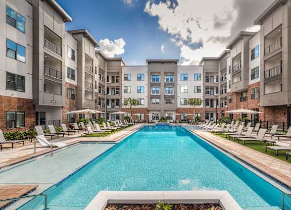 A large swimming pool in the middle of apartment buildings.