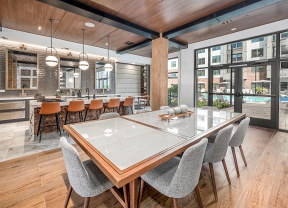 a dining area with a table and chairs and a kitchen with a pool at The Haven at Lake Britt Apartments, Winter Garden, 34787