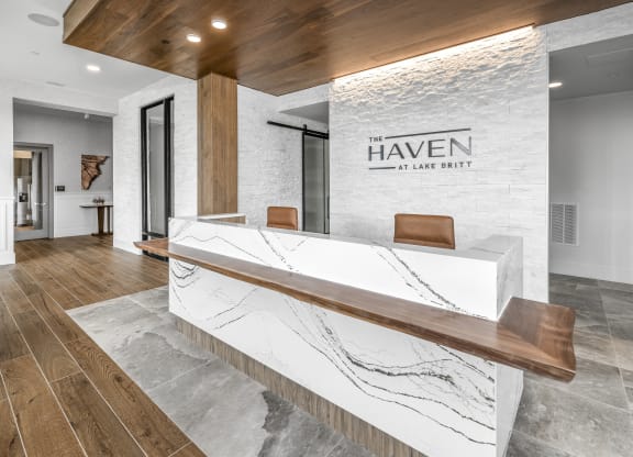 a reception desk in a hotel lobby with a large sign on the side of it at The Haven at Lake Britt Apartments, Winter Garden, FL