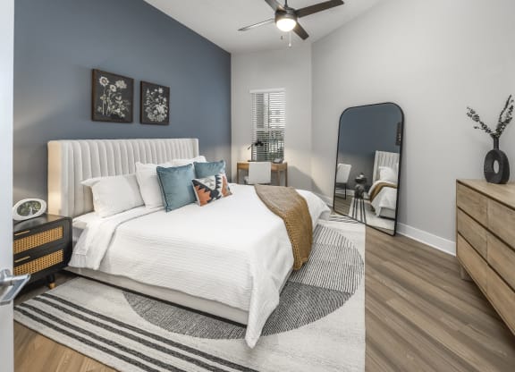 a bedroom with a large bed and a mirror at The Haven at Lake Britt Apartments, Winter Garden