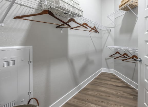 the walk in closet of a bedroom in a home with white walls and wood floors at The Haven at Lake Britt Apartments, Winter Garden, FL 34787
