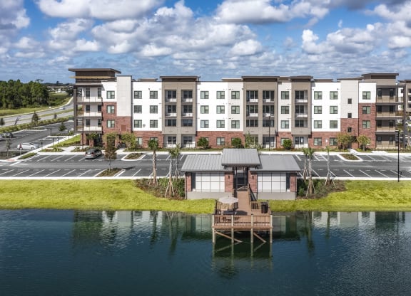 an aerial view of an apartment building overlooking a body of water at The Haven at Lake Britt Apartments, Winter Garden, FL