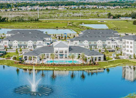 A large, well-maintained resort with a fountain in the foreground.