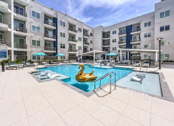 A swimming pool with a golden swan in the middle of it.