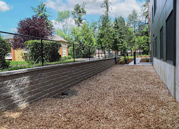 A long concrete wall with a black fence on top.