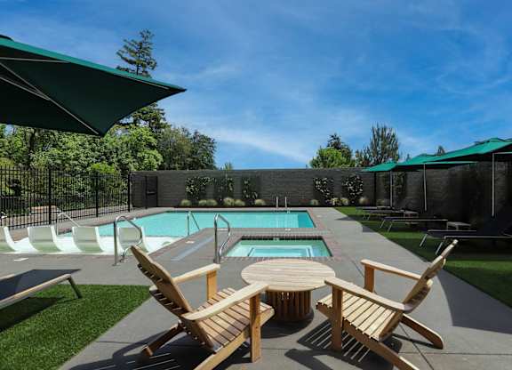 Outdoor pool with hot tub and wooden lounge chairs at Montage Apartments, Oregon