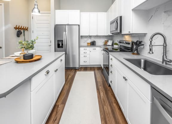 a large kitchen with white cabinets and stainless steel appliances at The Overlook, Winter Garden, FL, 34787