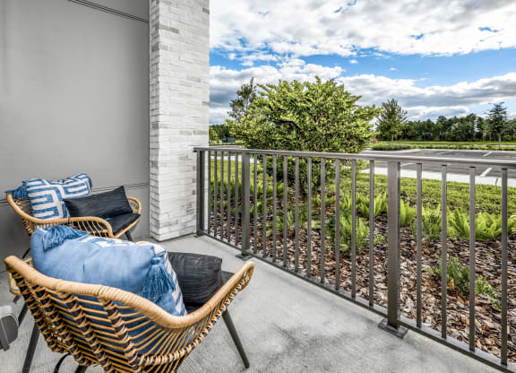 a balcony with two chairs and a view of a garden at The Overlook, Winter Garden, 34787