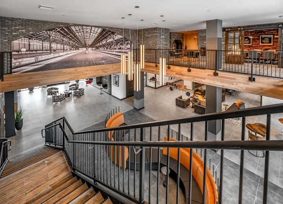 A modern interior with a staircase and a large mural on the wall at Parkway Crossings Apartments, Kissimmee