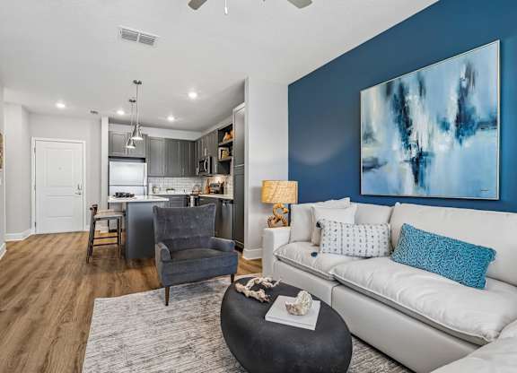 A modern living room with a grey armchair and a black coffee table.