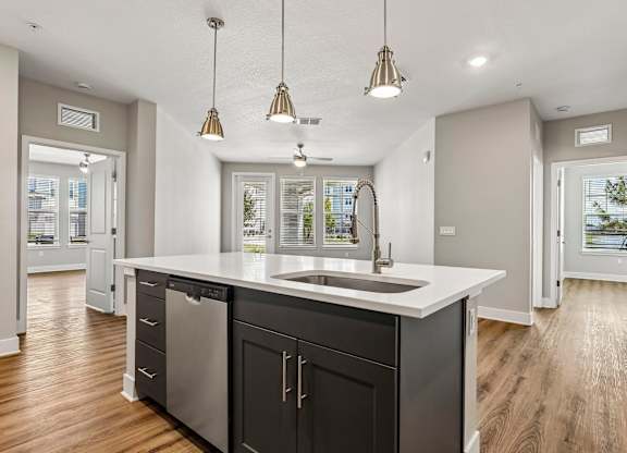 A modern kitchen with a large island and stainless steel appliances.