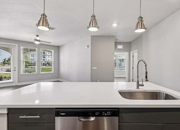 A modern kitchen with a stainless steel dishwasher and a white countertop.