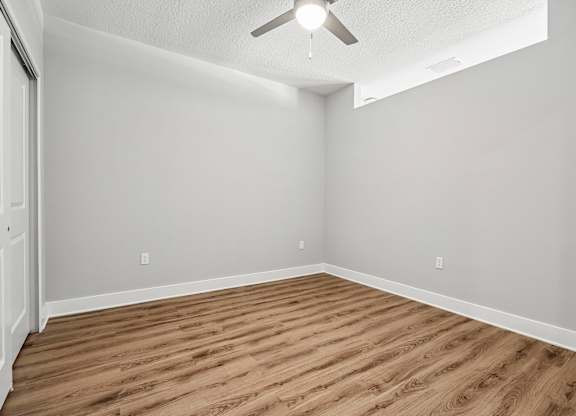 A room with a wooden floor and a ceiling fan.