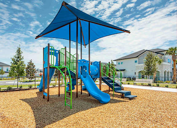 A playground with a blue canopy and a green slide.