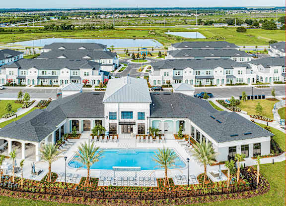 A large house with a pool in front.