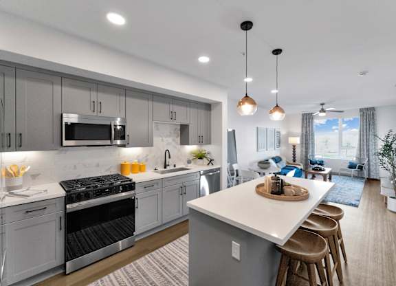 A modern kitchen with a large island and stainless steel appliances.