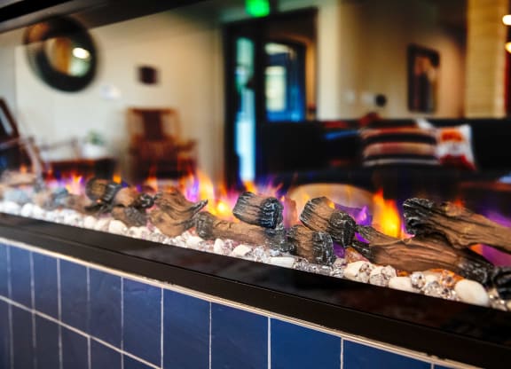 a fireplace in a restaurant with flames and rocks in front of it at Scouter's Mountain, Happy Valley, OR 97086