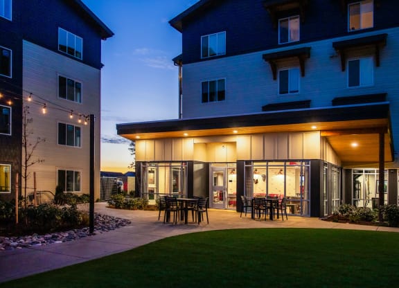 a patio with tables and chairs outside of a building at nightat Scouter's Mountain, Happy Valley, OR