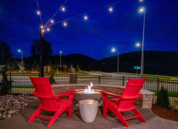 two red chairs around a fire pit on a patio at nightat Scouter's Mountain, Happy Valley, 97086