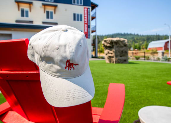 a hat with a red crab on it sits on a red chair in front of a buildingat Scouter's Mountain, Happy Valley