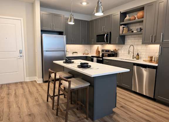 A kitchen with a white countertop and a stainless steel refrigerator.