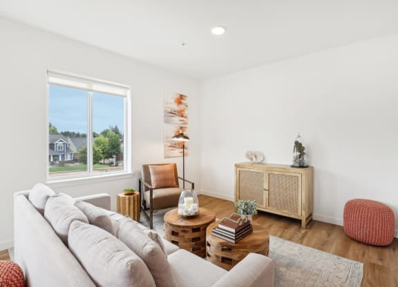 a living room with a couch and a window at The Mill on Maple Apartments, Oregon City, OR