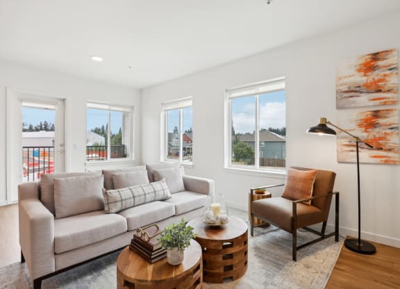 a living room with a couch and a coffee table and windows at The Mill on Maple Apartments, Oregon City, Oregon