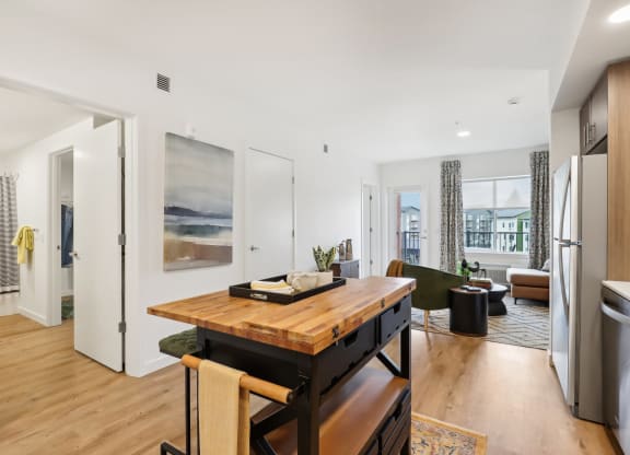 a living room with a wooden table and a kitchen at The Mill on Maple Apartments, Oregon City