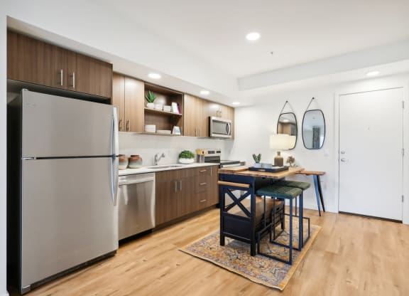 a kitchen with stainless steel appliances and a dining room table at The Mill on Maple Apartments, Oregon, 97045