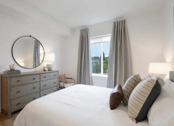 a bedroom with a bed and a dresser and a window at The Mill on Maple Apartments, Oregon City, OR 97045