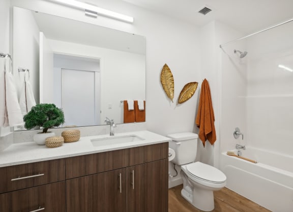 a bathroom with a toilet sink and shower and a mirror at The Mill on Maple Apartments, Oregon, 97045