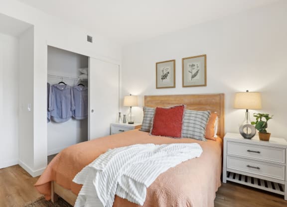 a bedroom with a bed and a closet with clothes in it at The Mill on Maple Apartments, Oregon