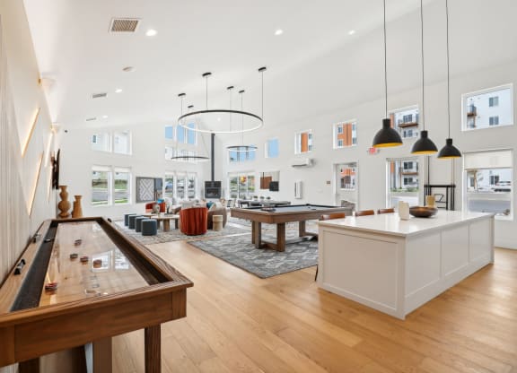 a living room with a ping pong table and a kitchen at The Mill on Maple Apartments, Oregon City, Oregon
