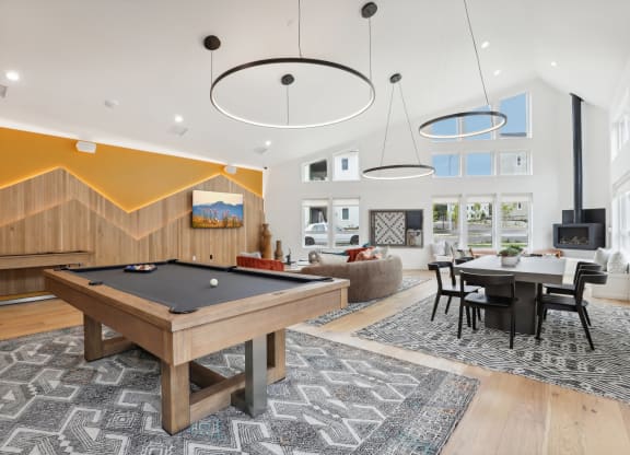 a spacious living room with a pool table and a dining room at The Mill on Maple Apartments, Oregon City, OR 97045