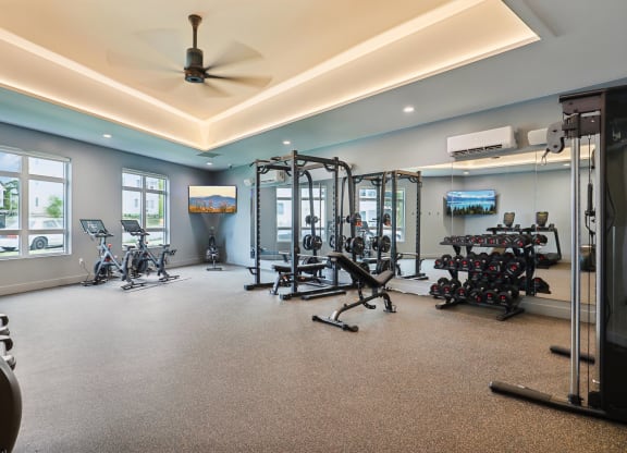 a gym with weights and other exercise equipment on the floor and windows at The Mill on Maple Apartments, Oregon City