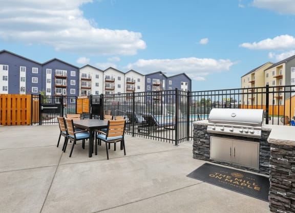 a patio with a grill and a table and chairs at The Mill on Maple Apartments, Oregon