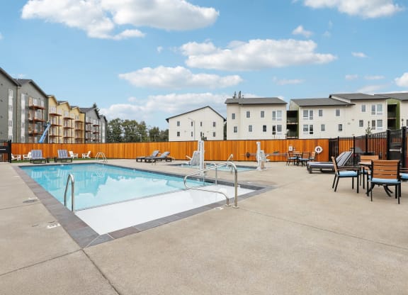 our apartments have a resort style pool with chairs and tables at The Mill on Maple Apartments, Oregon City, 97045