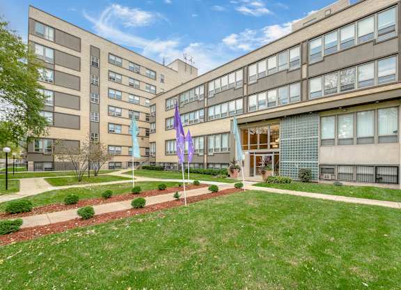 A building with a green lawn in front of it. at Academy at Drexel Apartments, Chicago, 60637