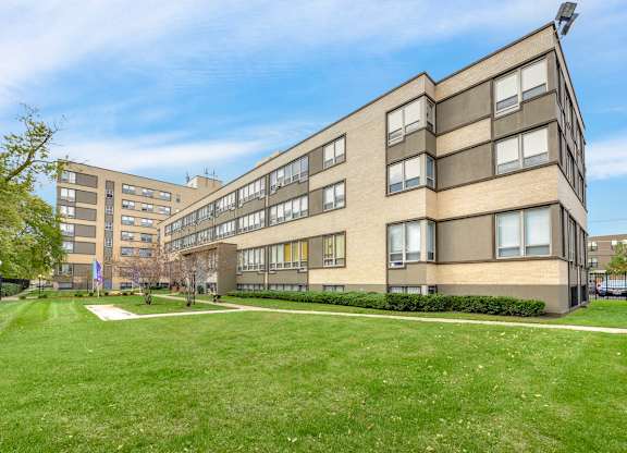 A large building with a green lawn in front. at Academy at Drexel Apartments, Illinois, 60637