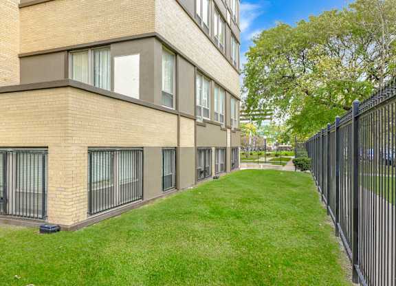 A long building with a black fence on the right side. at Academy at Drexel Apartments, Chicago, 60637
