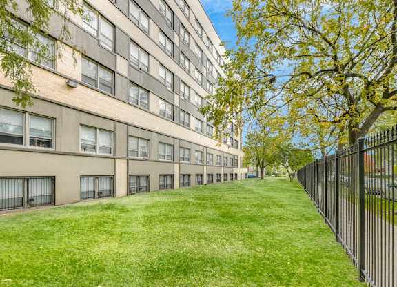 A long building with a black fence on the right side. at Academy at Drexel Apartments, Chicago, IL