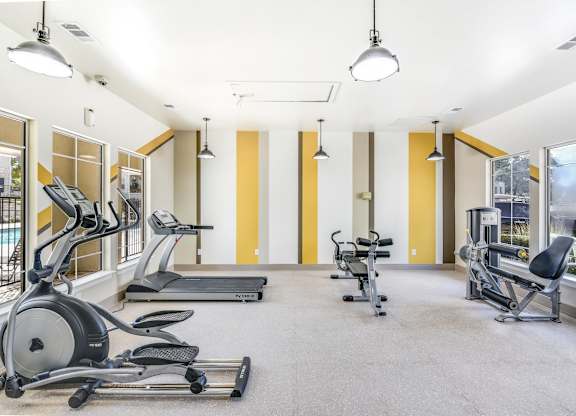A gym with treadmills, elliptical machines, and other exercise equipment.