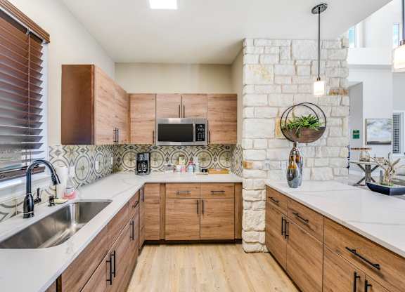 A kitchen with wooden cabinets and a stone backsplash.