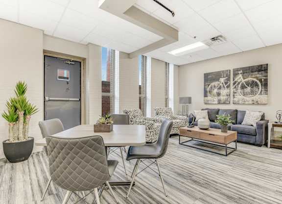 A modern living room with a grey dining table and grey chairs. at Academy at Drexel Apartments, Chicago, IL