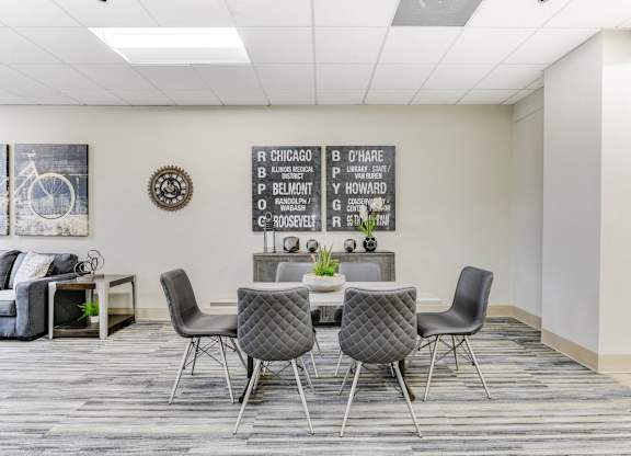 A conference room with a table and chairs and a board with names on it. at Academy at Drexel Apartments, Illinois