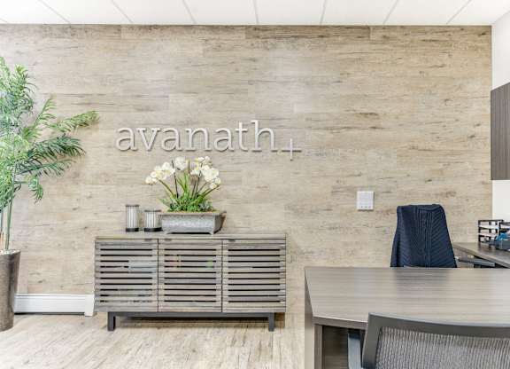 A modern office with a wooden wall and a grey table. at Academy at Drexel Apartments, Illinois, 60637